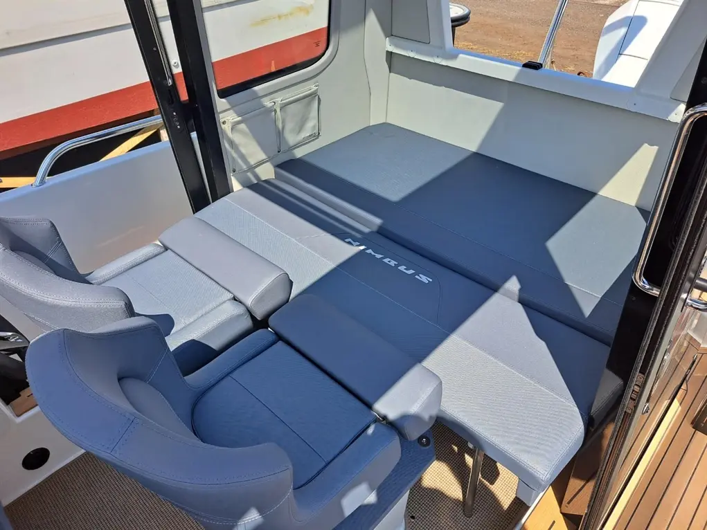 Interior view of a boat cockpit with grey cushions and seats labeled "Nimbus," showcasing modern marine seating design.